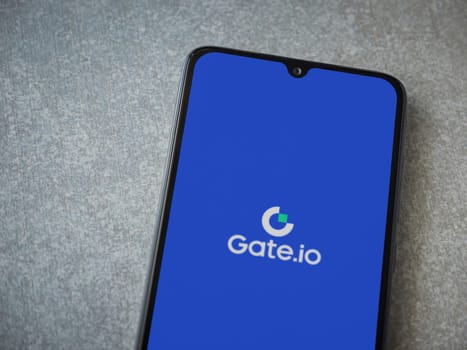 Lod, Israel - July 16,2023: Gate.io app launch screen on smartphone on ceramic stone background. Top view flat lay with copy space.