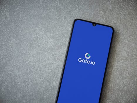 Lod, Israel - July 16,2023: Gate.io app launch screen on smartphone on ceramic stone background. Top view flat lay with copy space.