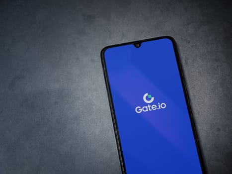 Lod, Israel - July 16,2023: Gate.io app launch screen on smartphone on dark marble stone background. Top view flat lay with copy space.