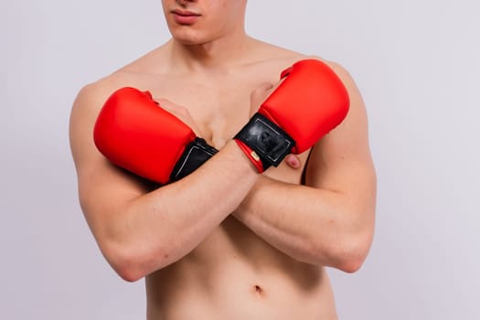 Bodybuilders boxing gloves on a white background and white pants athlete model