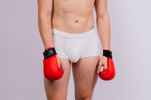 Bodybuilders boxing gloves on a white background and white pants athlete model