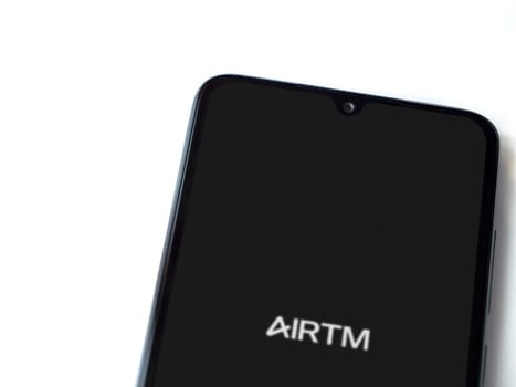 Lod, Israel - July 16,2023: AirTM app launch screen on smartphone on white background. Top view flat lay with copy space.