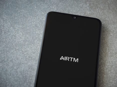Lod, Israel - July 16,2023: AirTM app launch screen on smartphone on ceramic stone background. Top view flat lay with copy space.