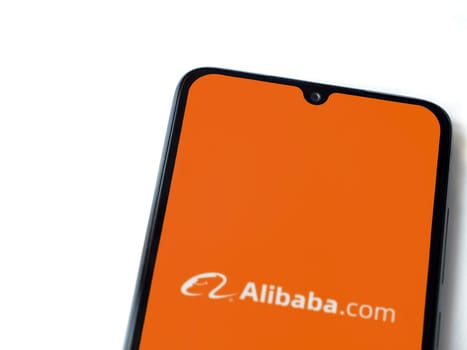 Lod, Israel - July 16,2023: Alibaba.com app launch screen on smartphone on white background. Top view flat lay with copy space.