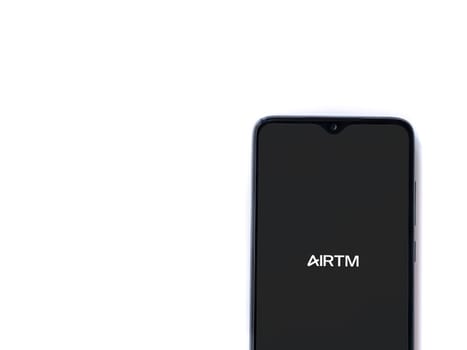 Lod, Israel - July 16,2023: AirTM app launch screen on smartphone on white background. Top view flat lay with copy space.