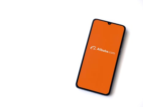 Lod, Israel - July 16,2023: Alibaba.com app launch screen on smartphone on white background. Top view flat lay with copy space.