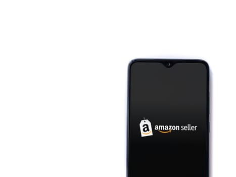 Lod, Israel - July 16,2023: Amazon Seller app launch screen on smartphone on white background. Top view flat lay with copy space.