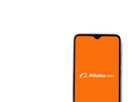 Lod, Israel - July 16,2023: Alibaba.com app launch screen on smartphone on white background. Top view flat lay with copy space.