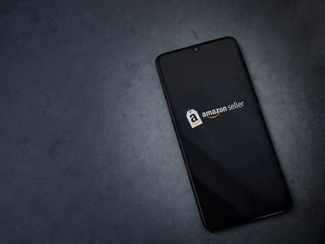 Lod, Israel - July 16,2023: Amazon Seller app launch screen on smartphone on dark marble stone background. Top view flat lay with copy space.