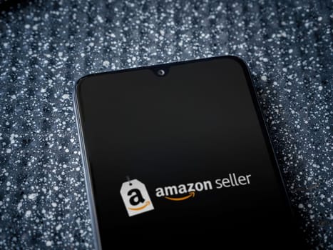 Lod, Israel - July 16,2023: Amazon Seller app launch screen on smartphone on metallic background. Close up top view flat lay.
