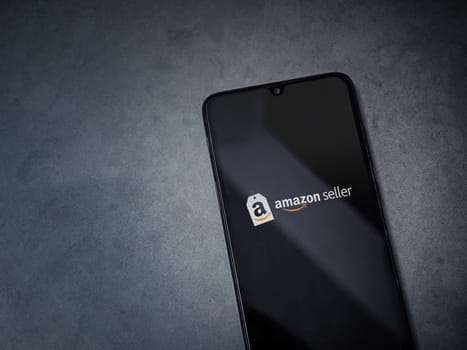 Lod, Israel - July 16,2023: Amazon Seller app launch screen on smartphone on dark marble stone background. Top view flat lay with copy space.