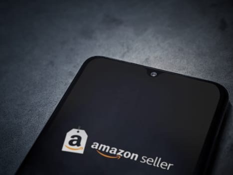 Lod, Israel - July 16,2023: Amazon Seller app launch screen on smartphone on dark marble stone background. Top view flat lay with copy space.
