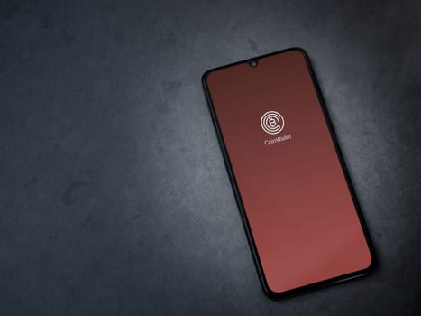 Lod, Israel - July 16,2023: CoinWallet app launch screen on smartphone on dark marble stone background. Top view flat lay with copy space.