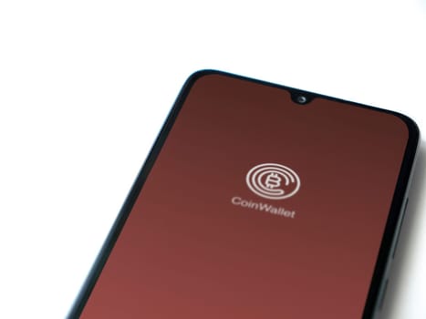 Lod, Israel - July 16,2023: CoinWallet app launch screen on smartphone on white background. Top view flat lay with copy space.