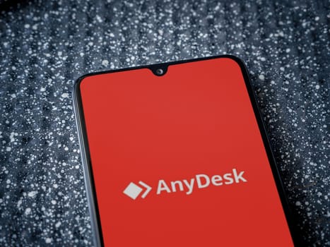 Lod, Israel - July 16,2023: Anydesk app launch screen on smartphone on metallic background. Close up top view flat lay.