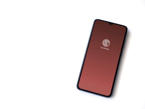 Lod, Israel - July 16,2023: CoinWallet app launch screen on smartphone on white background. Top view flat lay with copy space.