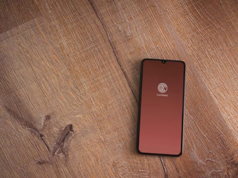 Lod, Israel - July 16,2023: CoinWallet app launch screen on smartphone on wooden background. Top view flat lay with copy space.