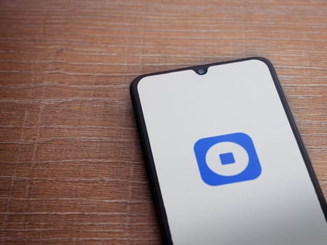 Lod, Israel - July 16,2023: Coinbase Wallet app launch screen on smartphone on wooden background. Top view flat lay with copy space.