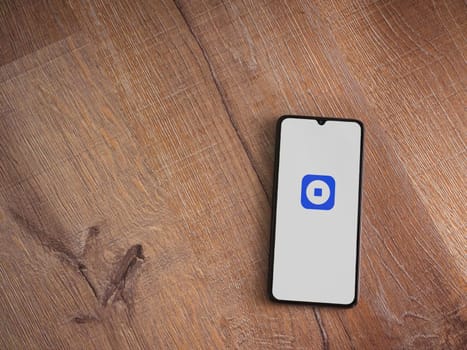 Lod, Israel - July 16,2023: Coinbase Wallet app launch screen on smartphone on wooden background. Top view flat lay with copy space.