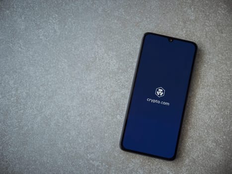 Lod, Israel - July 16,2023: Crypto.com app launch screen on smartphone on ceramic stone background. Top view flat lay with copy space.