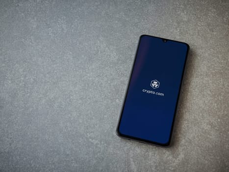 Lod, Israel - July 16,2023: Crypto.com app launch screen on smartphone on ceramic stone background. Top view flat lay with copy space.