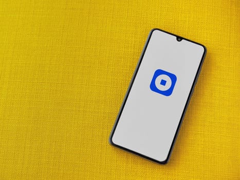 Lod, Israel - July 16,2023: Coinbase Wallet app launch screen on smartphone on yellow fabric background. Top view flat lay with copy space.