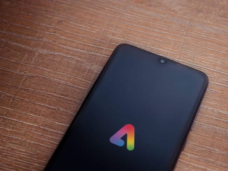 Lod, Israel - July 16,2023: Adobe Express - Graphic Design app launch screen on smartphone on wooden background.. Top view flat lay with copy space.