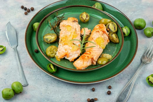 Salmon steaks grilled with mini kiwi on a plate. Diet food.