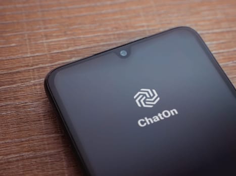 Lod, Israel - July 16,2023: ChatOn app launch screen on smartphone on wooden background. Top view flat lay with copy space.