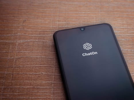 Lod, Israel - July 16,2023: ChatOn app launch screen on smartphone on wooden background. Top view flat lay with copy space.
