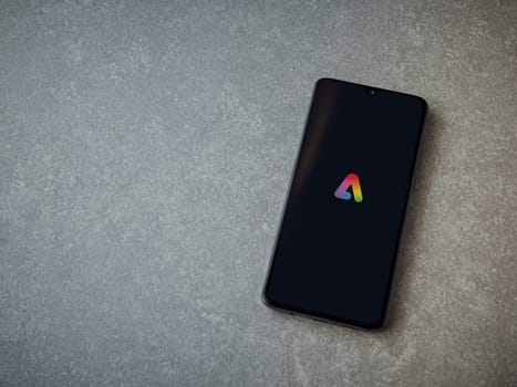 Lod, Israel - July 16,2023: Adobe Express - Graphic Design app launch screen on smartphone on ceramic stone background.. Top view flat lay with copy space.