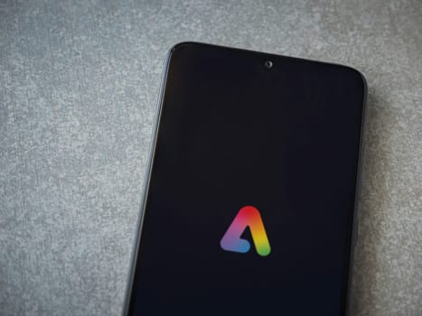 Lod, Israel - July 16,2023: Adobe Express - Graphic Design app launch screen on smartphone on ceramic stone background.. Top view flat lay with copy space.