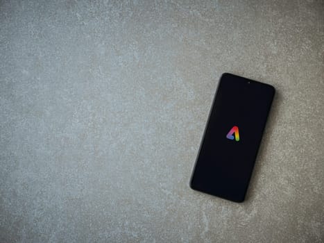 Lod, Israel - July 16,2023: Adobe Express - Graphic Design app launch screen on smartphone on ceramic stone background.. Top view flat lay with copy space.