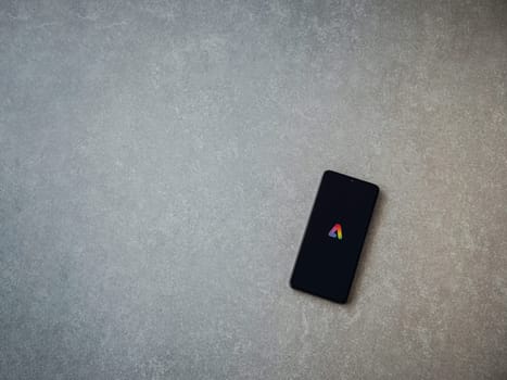 Lod, Israel - July 16,2023: Adobe Express - Graphic Design app launch screen on smartphone on ceramic stone background.. Top view flat lay with copy space.