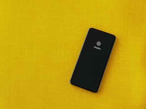 Lod, Israel - July 16,2023: ChatOn app launch screen on smartphone on yellow fabric background. Top view flat lay with copy space.