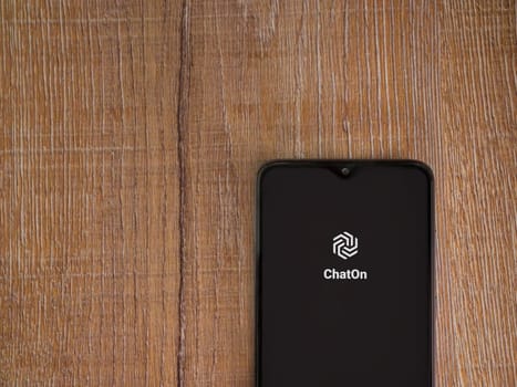 Lod, Israel - July 16,2023: ChatOn app launch screen on smartphone on wooden background. Top view flat lay with copy space.