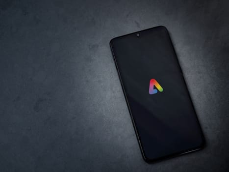 Lod, Israel - July 16,2023: Adobe Express - Graphic Design app launch screen on smartphone on dark marble stone background. Top view flat lay with copy space.