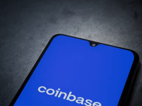 Lod, Israel - July 16,2023: Coinbase app launch screen on smartphone on dark marble stone background. Top view flat lay with copy space.