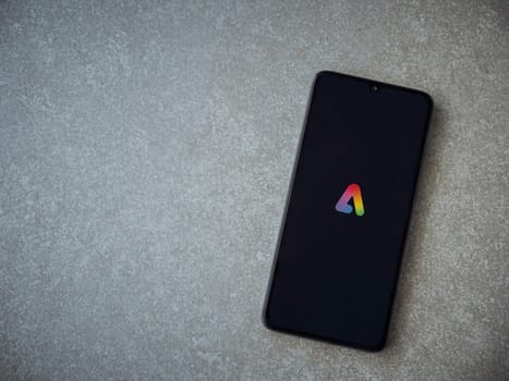 Lod, Israel - July 16,2023: Adobe Express - Graphic Design app launch screen on smartphone on ceramic stone background. Top view flat lay with copy space.