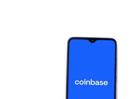 Lod, Israel - July 16,2023: Coinbase app launch screen on smartphone on white background. Top view flat lay with copy space.