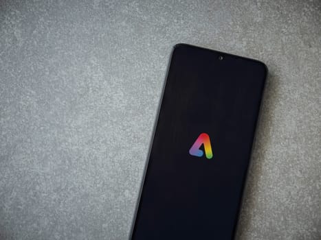 Lod, Israel - July 16,2023: Adobe Express - Graphic Design app launch screen on smartphone on ceramic stone background.. Top view flat lay with copy space.