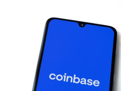 Lod, Israel - July 16,2023: Coinbase app launch screen on smartphone on white background. Top view flat lay with copy space.