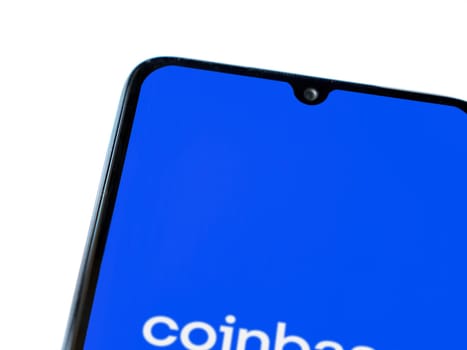 Lod, Israel - July 16,2023: Coinbase app launch screen on smartphone on white background. Top view flat lay with copy space.