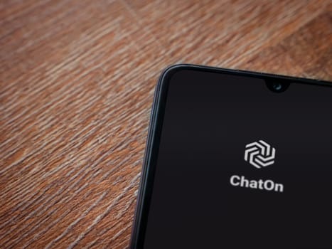 Lod, Israel - July 16,2023: ChatOn app launch screen on smartphone on wooden background. Top view flat lay with copy space.