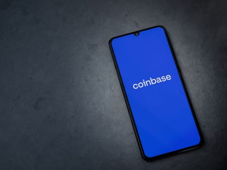 Lod, Israel - July 16,2023: Coinbase app launch screen on smartphone on dark marble stone background. Top view flat lay with copy space.