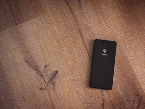 Lod, Israel - July 16,2023: ChatOn app launch screen on smartphone on wooden background. Top view flat lay with copy space.