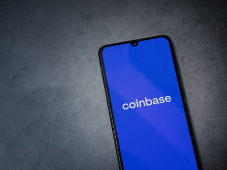Lod, Israel - July 16,2023: Coinbase app launch screen on smartphone on dark marble stone background. Top view flat lay with copy space.