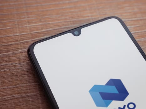 Lod, Israel - July 16,2023: Nexo app launch screen on smartphone on wooden background. Top view flat lay with copy space.