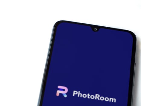 Lod, Israel - July 16,2023: PhotoRoom Studio Photo Editor app launch screen on smartphone on white background.. Top view flat lay with copy space.