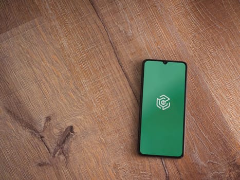 Lod, Israel - July 16,2023: Adam Ai app launch screen on smartphone on wooden background. Top view flat lay with copy space.